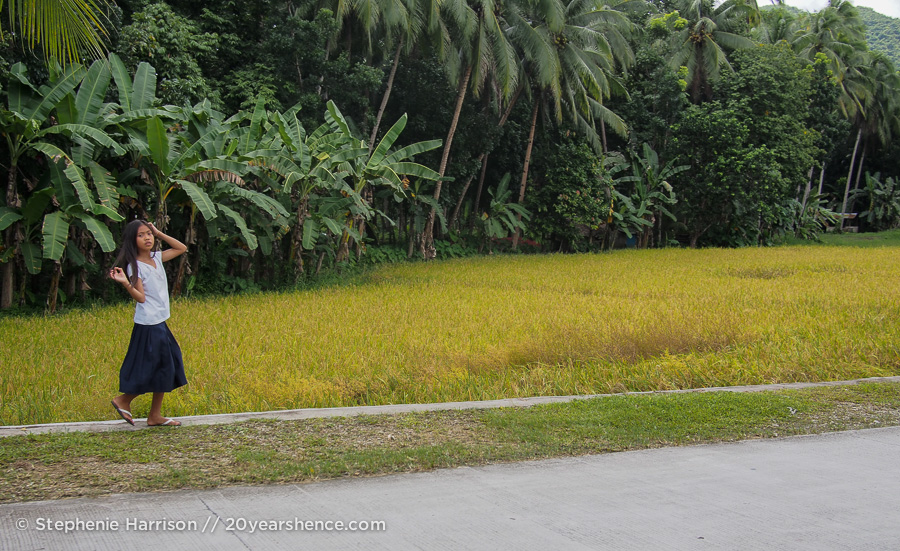 A girl walks next to rice paddies in Bohol, Philippines