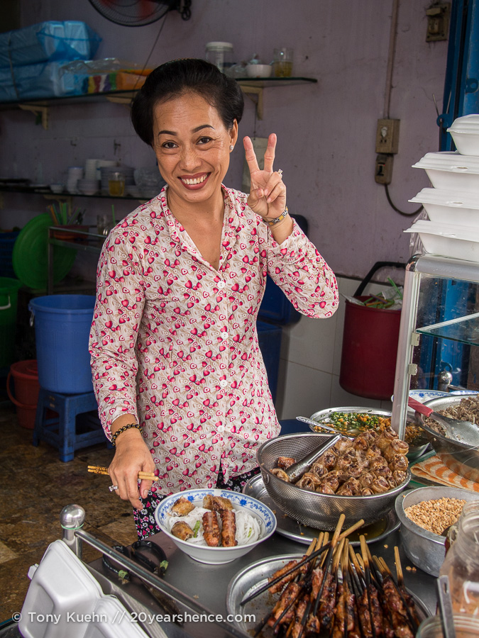Smiling Vietnamese woman serves food